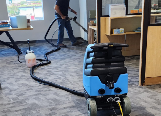 técnico realizando limpieza profunda de alfombra en una oficina comercial